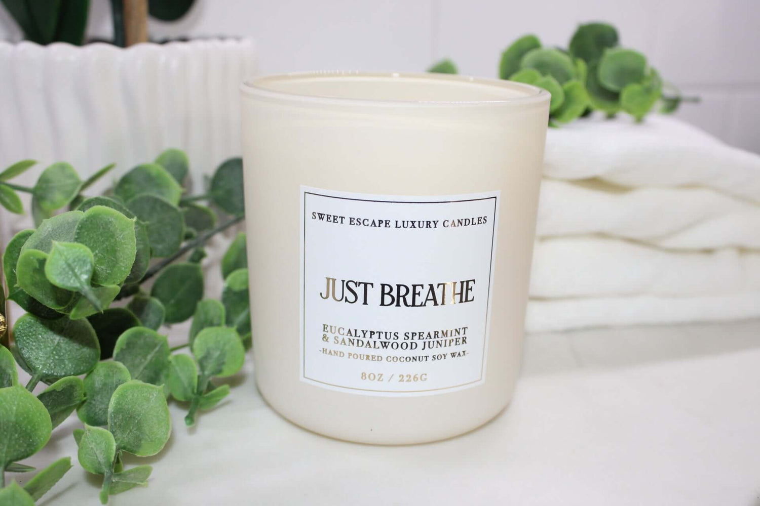 ust Breathe candle by Sweet Escape Luxury Candles, featuring a soothing blend of marine, spearmint, eucalyptus, sea salt, juniper, sandalwood, and fresh thyme. Infused with essential oils, perfect for a relaxing home spa experience